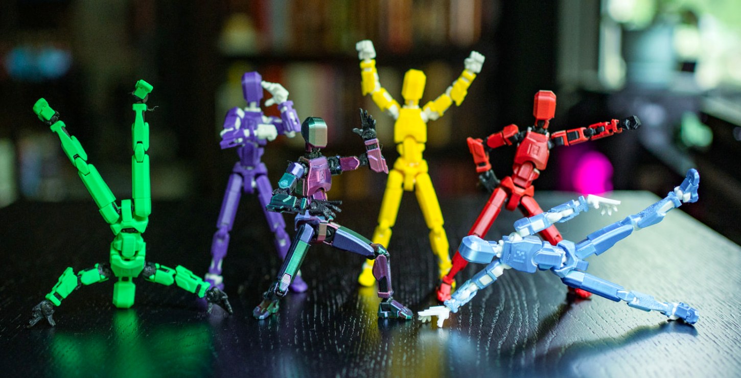 Colorful articulated T-13 action figures posed on a desk
